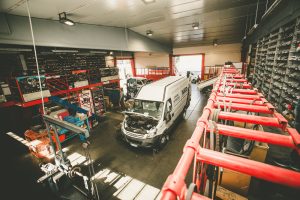 Officina meccanica con furgone bianco in riparazione.