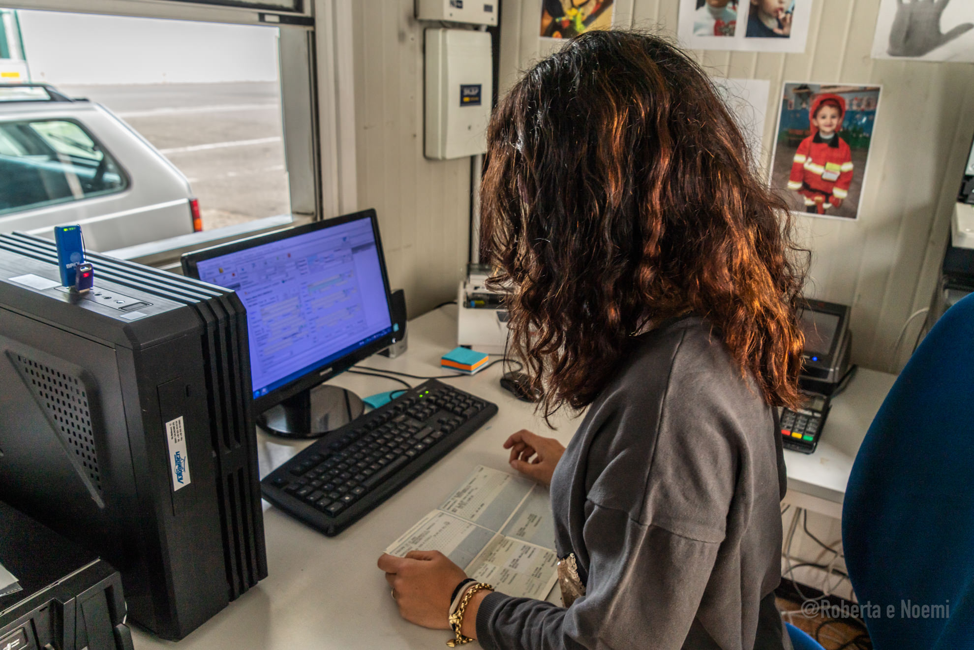 Persona lavora al computer in ufficio con documenti.