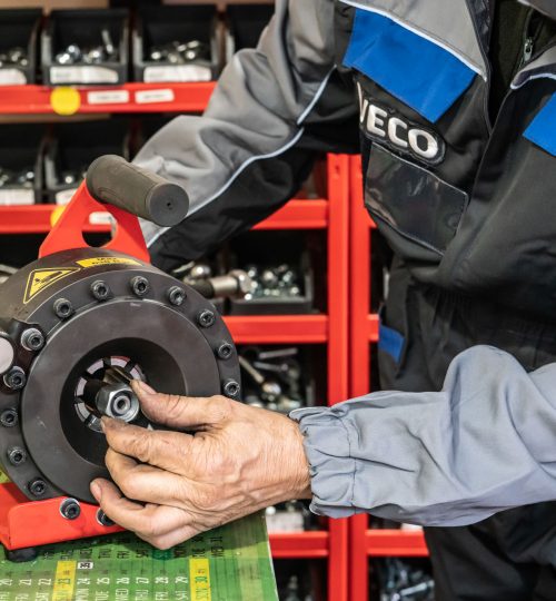 Persona lavora su attrezzatura meccanica in officina.