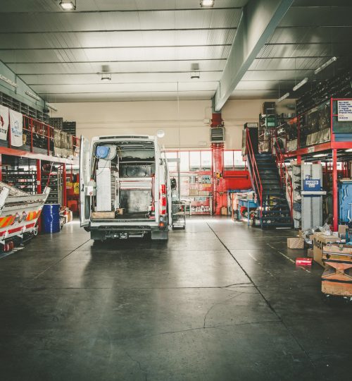 Interno di un'officina con furgone e attrezzature.