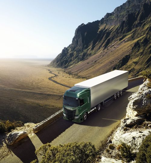 Camion verde su strada montana con vista panoramica.